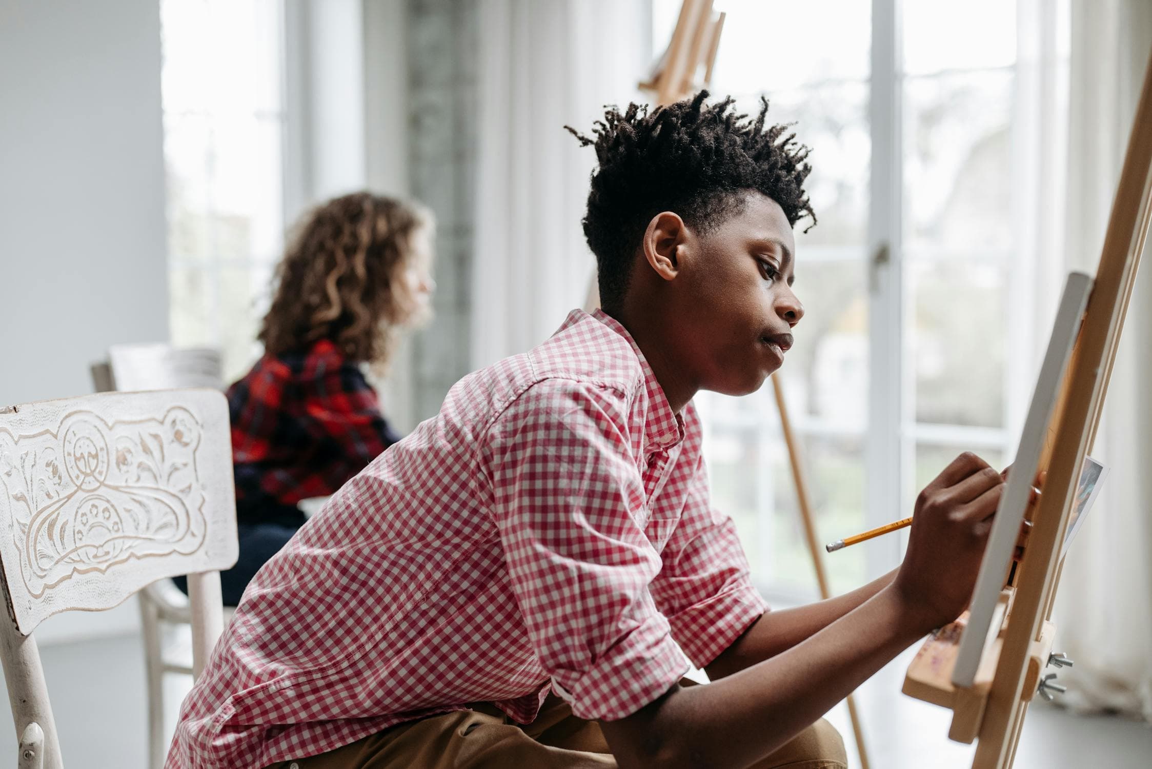 Adults painting on canvas during an art class