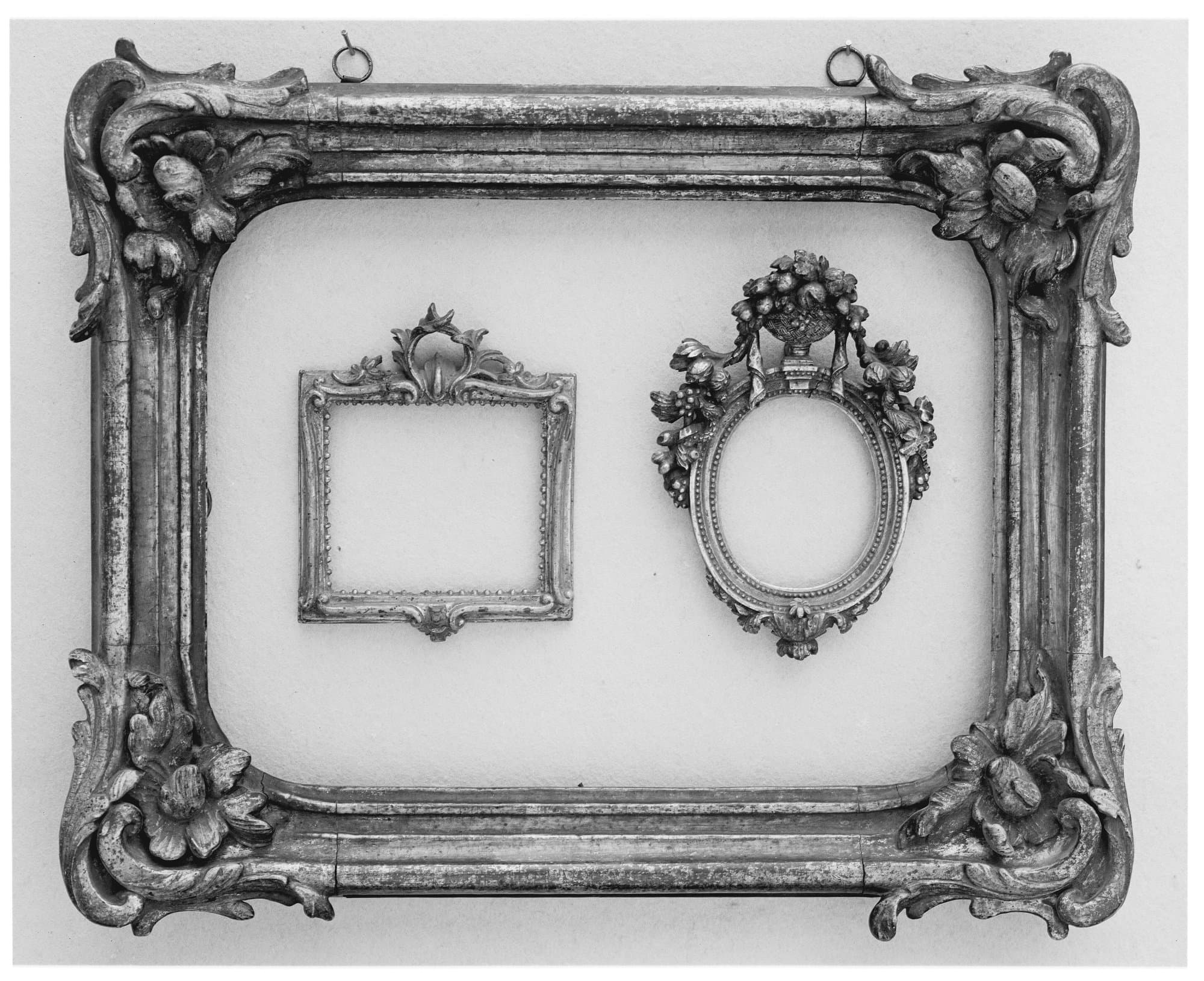 An eighteenth century French carved and gilded wood frame holding two smaller ornamental frames