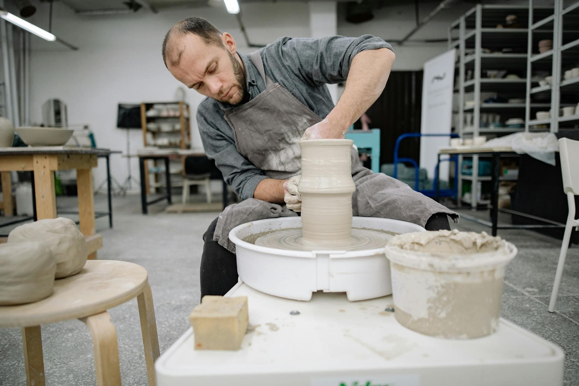Hands shaping clay on a pottery wheel in a ceramics studio
