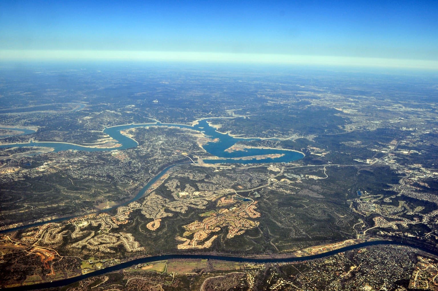 Aerial view of Lake Travis winding through the wooded hills west of Austin