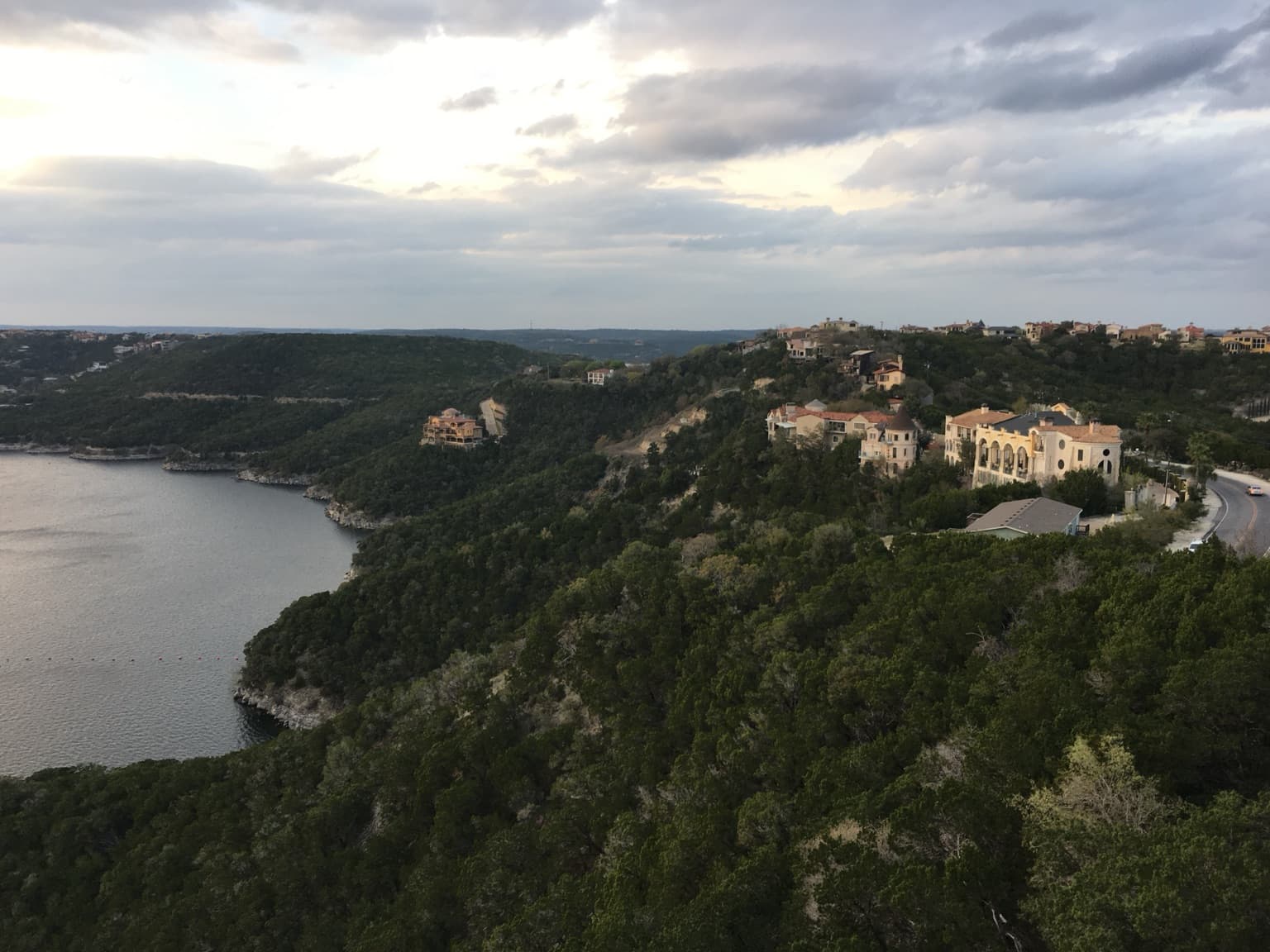 Sunset fading over Lake Travis and its layered hills, seen from the Oasis