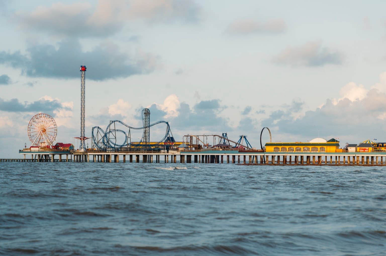 The Galveston Island Historic Pleasure Pier stretching over the Gulf of Mexico, with amusement rides above the water