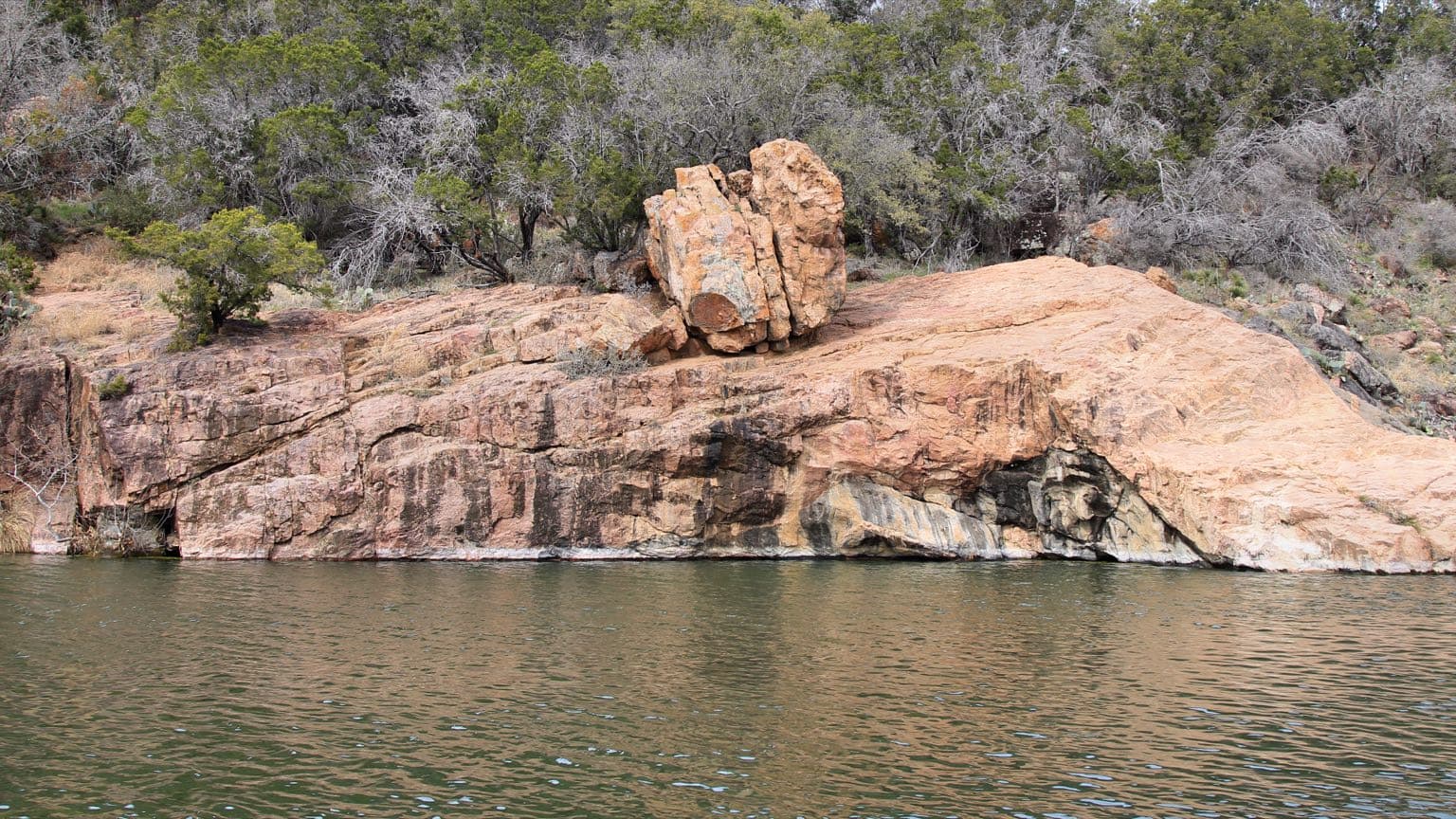Granite ledges ringing the swimming area at Devil's Waterhole in Inks Lake State Park, a short drive from Kingsland