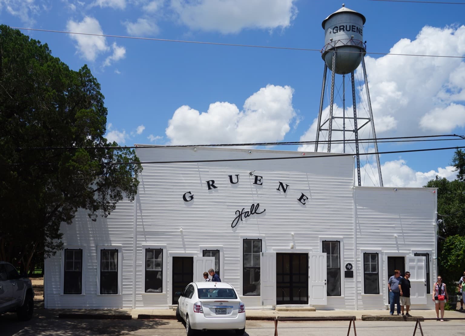 Gruene Hall's white clapboard facade under the historic Gruene water tower on a bright summer day in New Braunfels, Texas