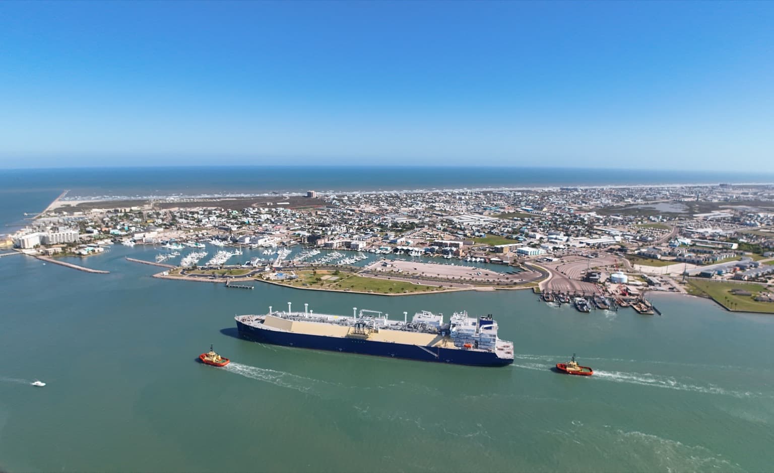 Aerial view of Port Aransas, Texas, with the ship channel, jetties, and Mustang Island's beaches stretching south