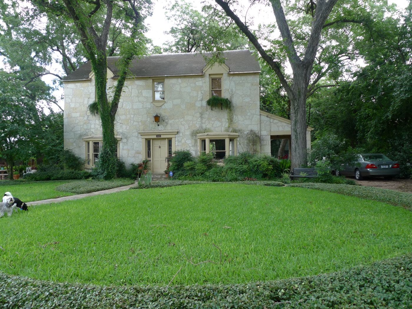 A restored nineteenth-century home shaded by mature trees in San Antonio's King William Historic District