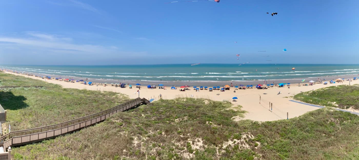 The Gulf beach on South Padre Island seen from a condo, with clear green water and light crowds