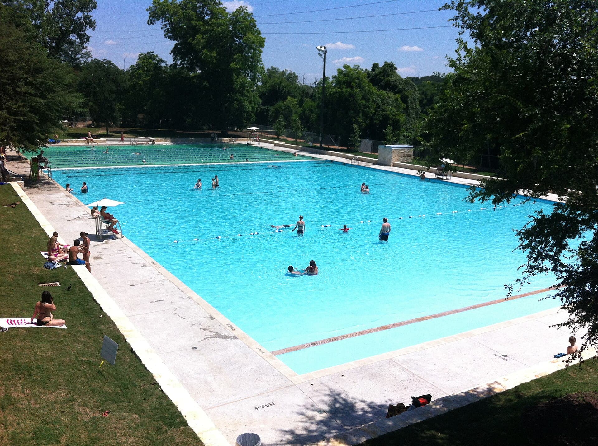 Swimmers at Deep Eddy Pool in Austin, the spring-fed historic 1930s public pool with its iconic bath house