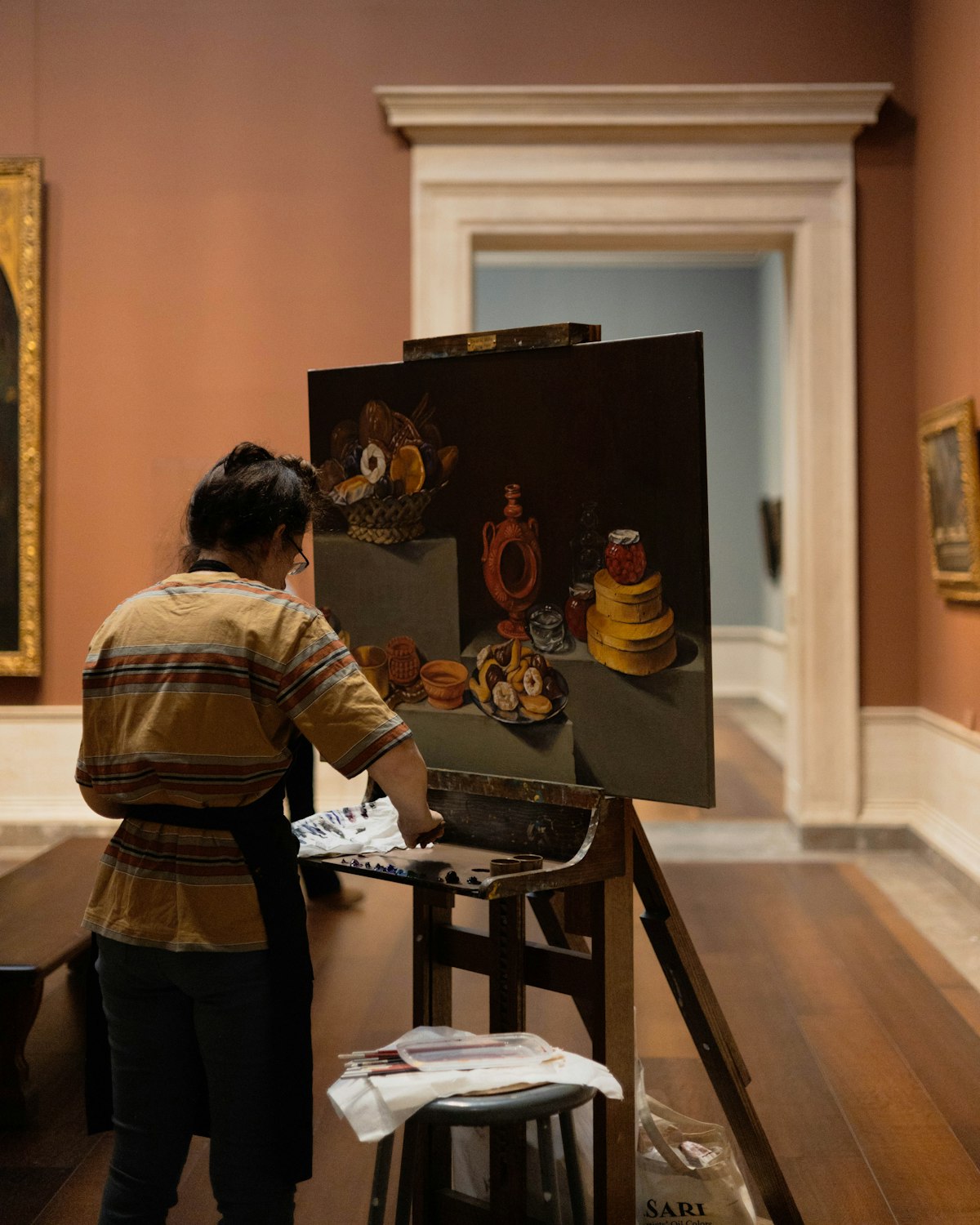 Person examining artwork in a gallery setting