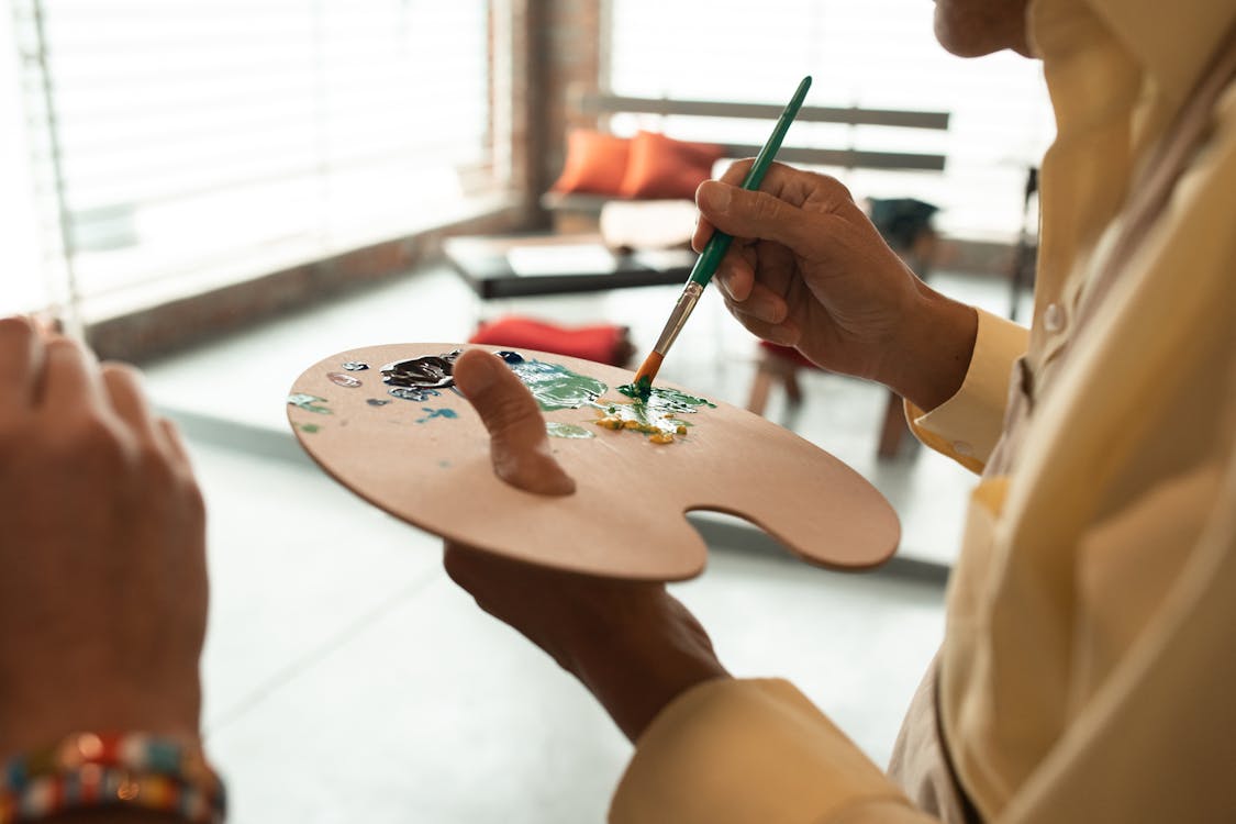 A collector carefully examining a framed artwork using cotton gloves and proper handling technique