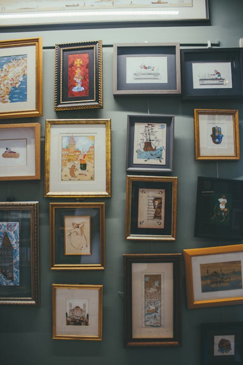 Salon-style gallery wall with mixed frame sizes and artwork types arranged with consistent spacing