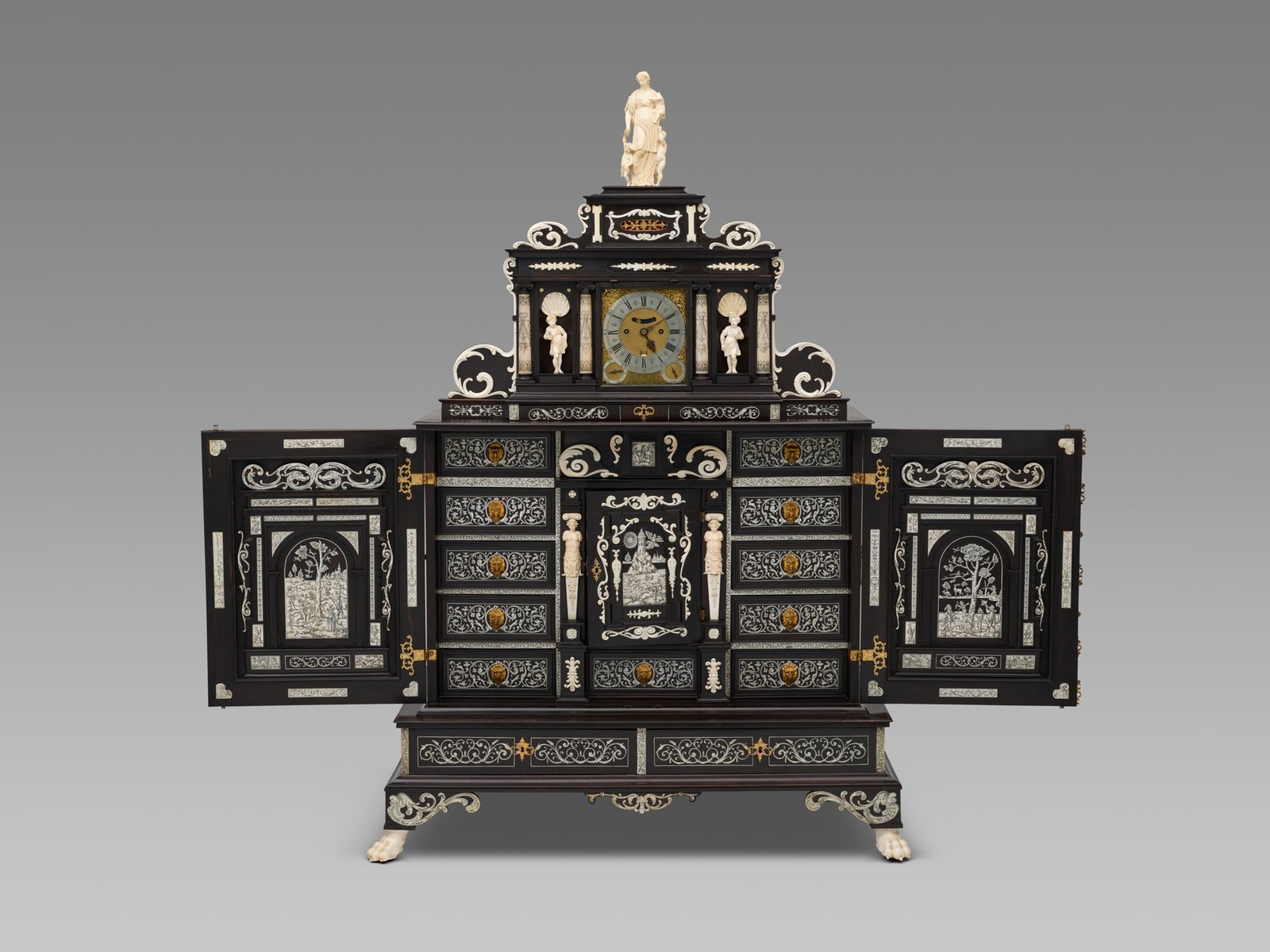 A seventeenth century Augsburg collector's cabinet in ebony with ivory figures, many small drawers and open doors