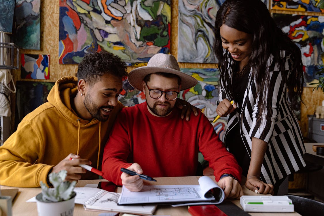 Visitors browsing artwork and engaging with an artist at an art fair booth