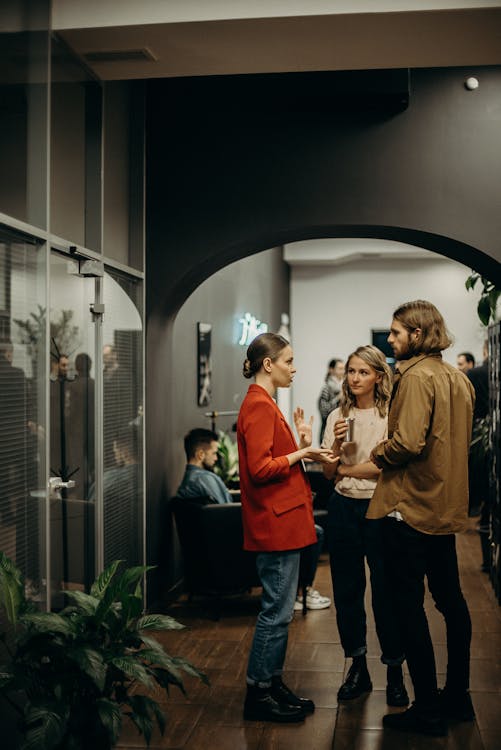 A visitor engaged in conversation with an artist at a gallery opening