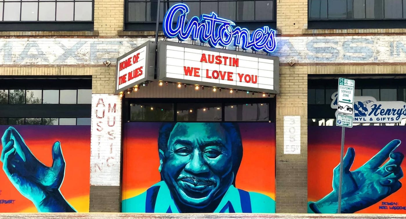 A bold blue-and-orange portrait mural of a blues musician by Chris Rogers on the Antone's building in Austin