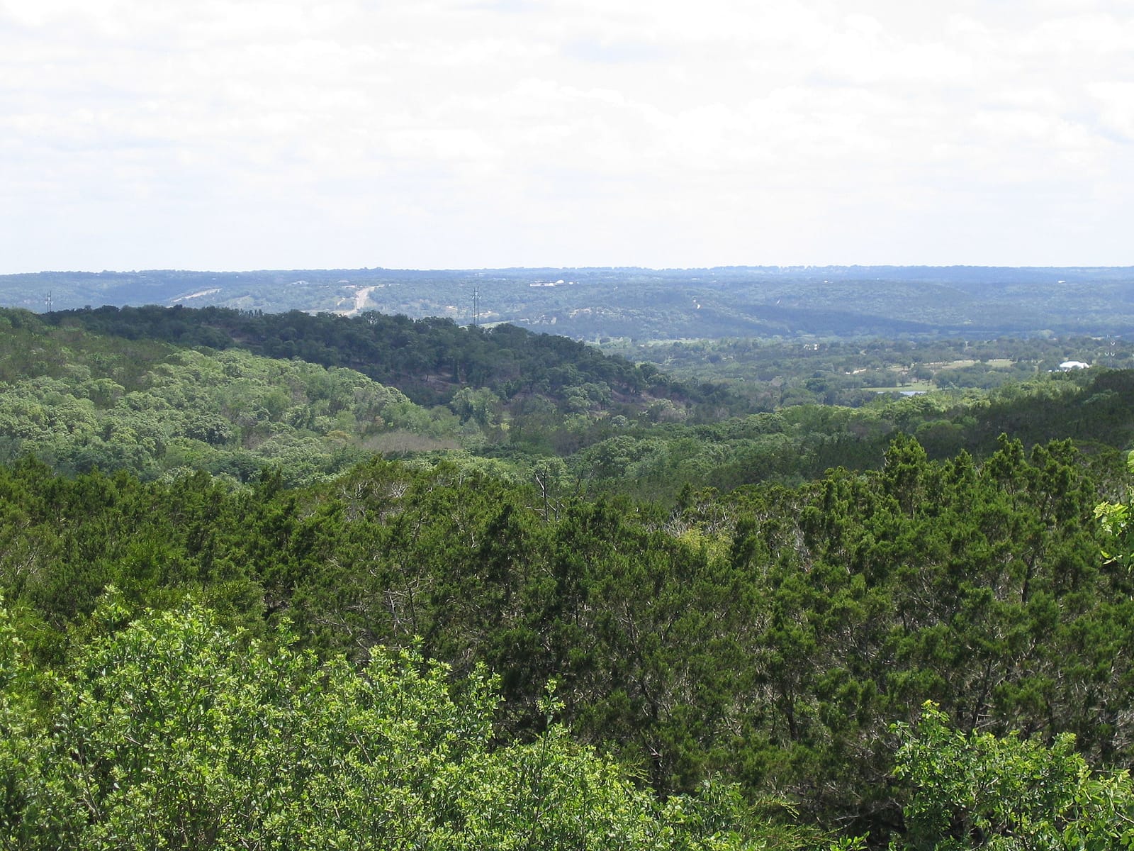 Sunset over cedar-covered Hill Country ridgelines west of Austin