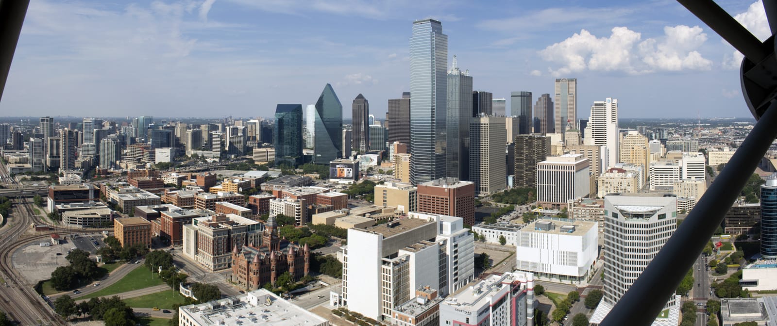 The downtown Dallas skyline rising over the Trinity River at dusk
