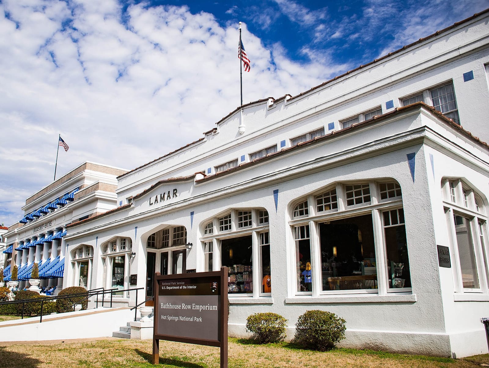 Historic 1900s bathhouses along Bathhouse Row with forested mountains rising behind downtown Hot Springs
